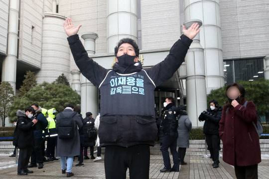 국정농단 사건에 연루돼 재판에 넘겨진 이재용 삼성전자 부회장이 파기환송심에서 징역형의 실형을 선고받은 18일 오후 서울 서초동 서울고등법원 앞에서 삼성해고자복직투쟁위원회 관계자가 재판 결과를 듣고서 기뻐하고 있다. <연합뉴스>